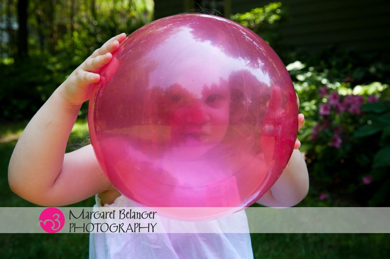 Little girl looking through a pink ball, Boston area