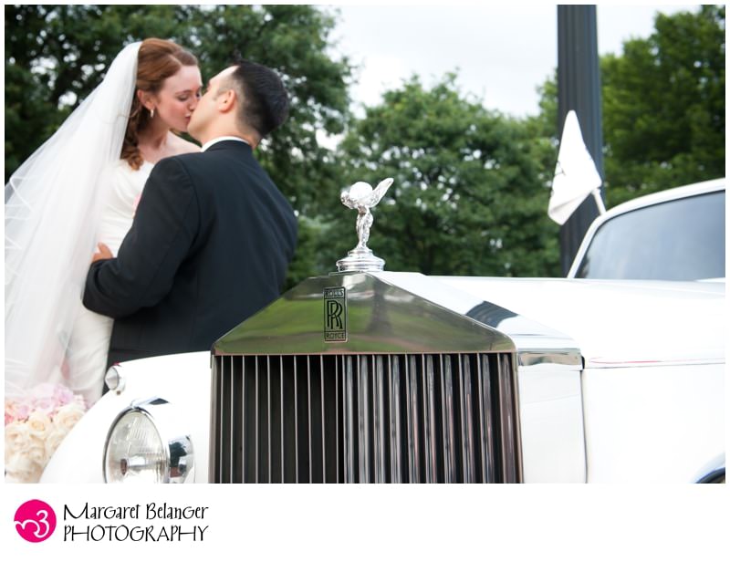 Bride and groom kissing by the Rolls Royce