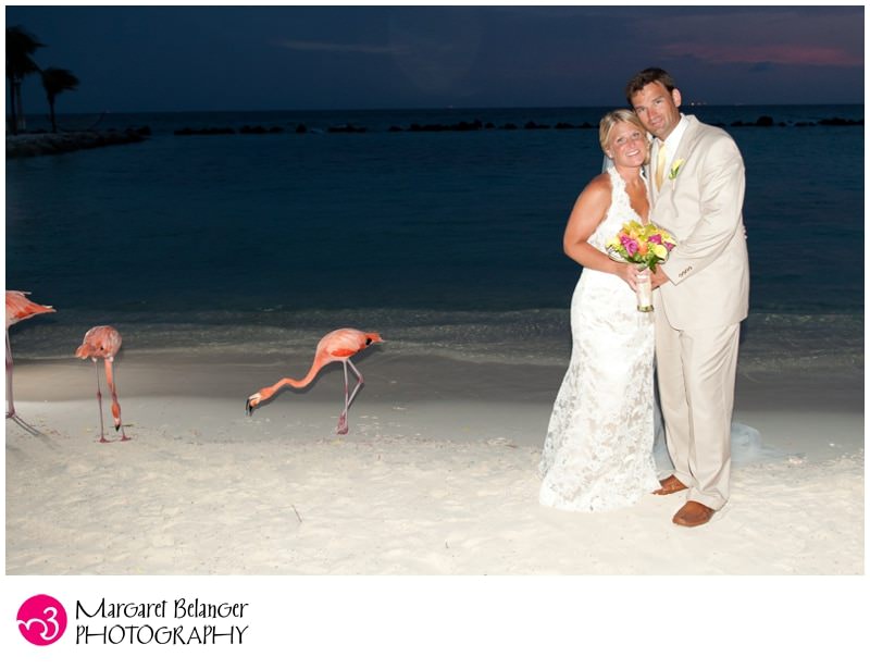 Bride and groom on beach with flamingoes, Aruba destination wedding