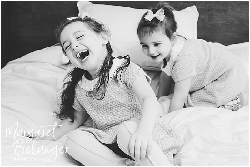Brookline newborn session, sisters playing on bed