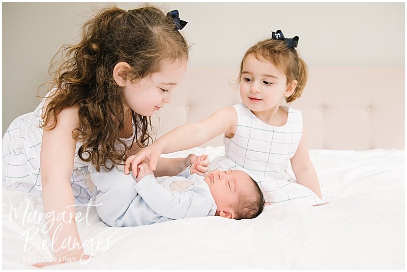 Brookline newborn session, sisters on bed playing with baby