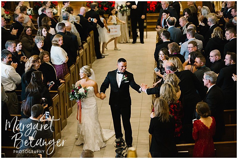 Bride and groom process down aisle at the end of their winter wedding ceremony