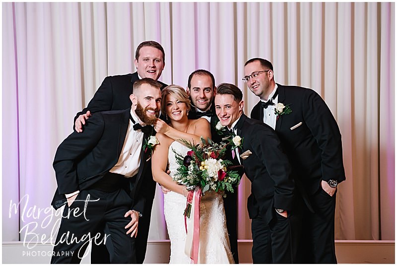 Casual photo of the bride posing with the groomsmen