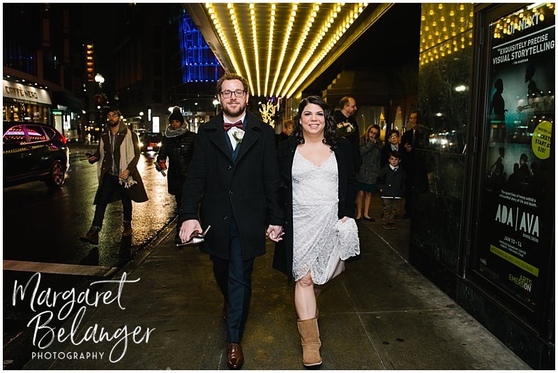 Bride and groom walking through Downtown Crossing on the way to their winter wedding at an intimate Boston restaurant