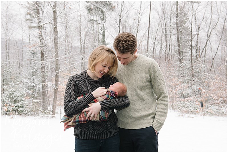 Parents hold baby outside in snow, New Hampshire newborn session