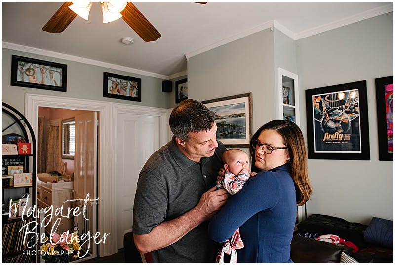 South Shore newborn session, mom holding baby girl on her shoulder and dad snuggles in