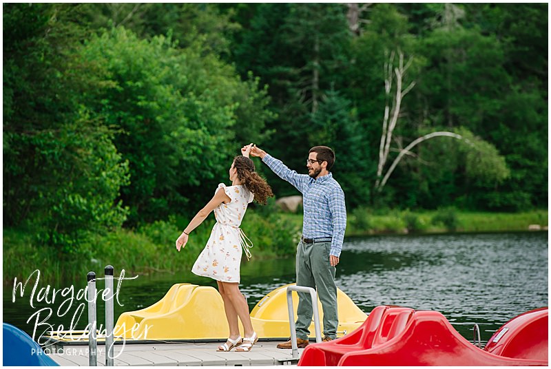 Couple dancing on a dock among colorful paddle boats at Waterville Valley
