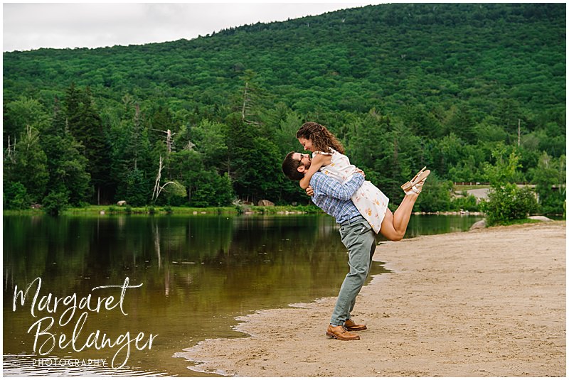 Groom picking up his bride at the edge of the lake at Waterville Valley Resort