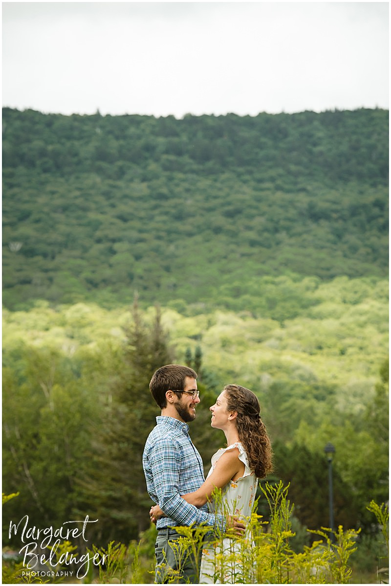 Couple hugs among the tall grasses at Waterville Valley