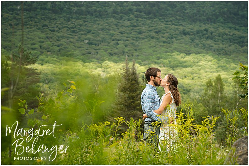 Couple kisses among the tall grasses at Waterville Valley