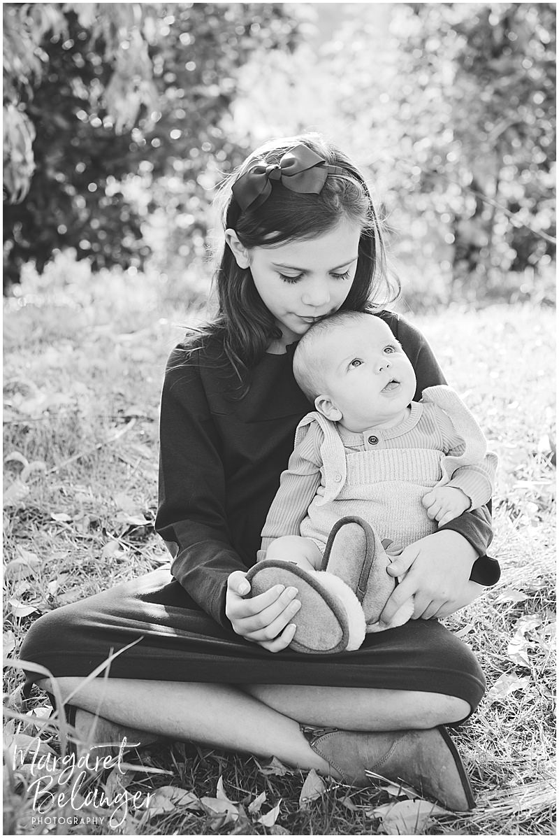 Black & white photo of girl holding her baby brother in an orchard, Boston Hill Farm Andover