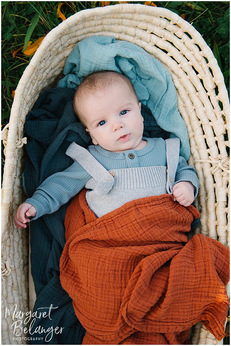 Baby boy in a moses basket gazing up at the camera, Boston Hill Farm, Andover