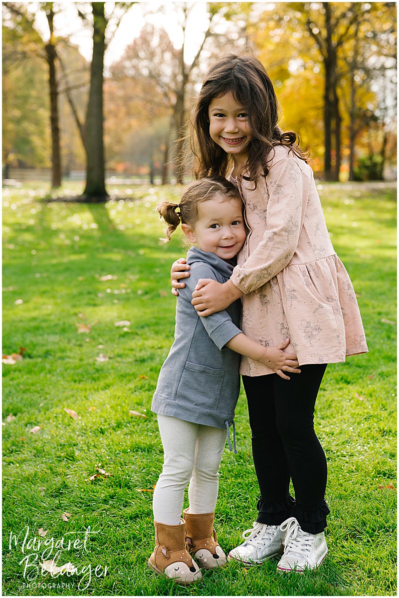 Sisters hugging during their fall family session at Endicott Park in Danvers.