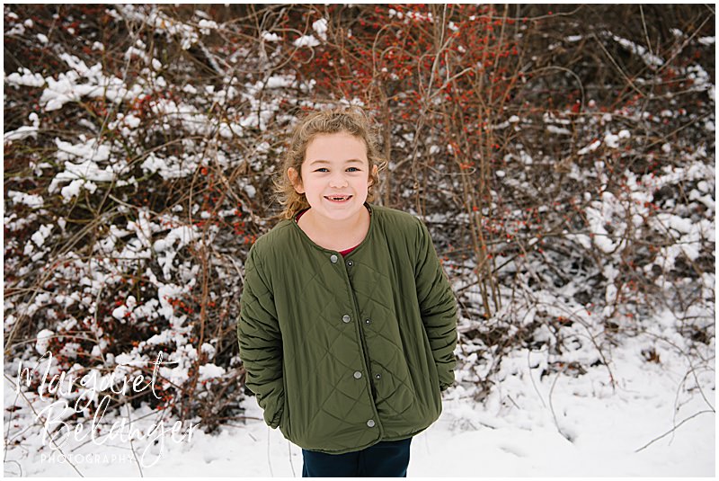 Portrait of the youngest sister in the snow during a winter family session in Minute Man National Park in Lincoln.