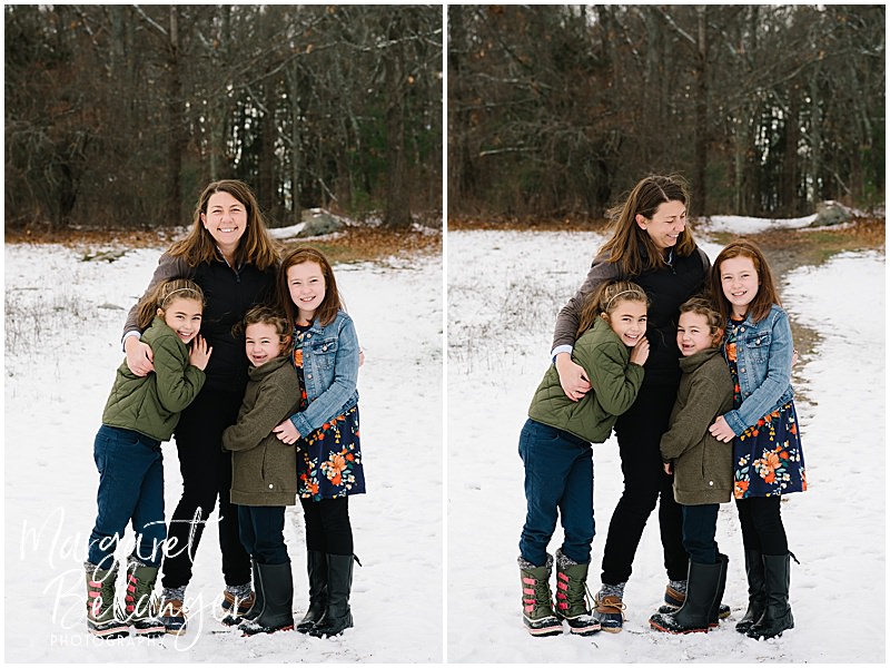 Three sisters and their Mom standing together and hugging in the snow during their winter family session at Minute Man National Park in Lincoln.