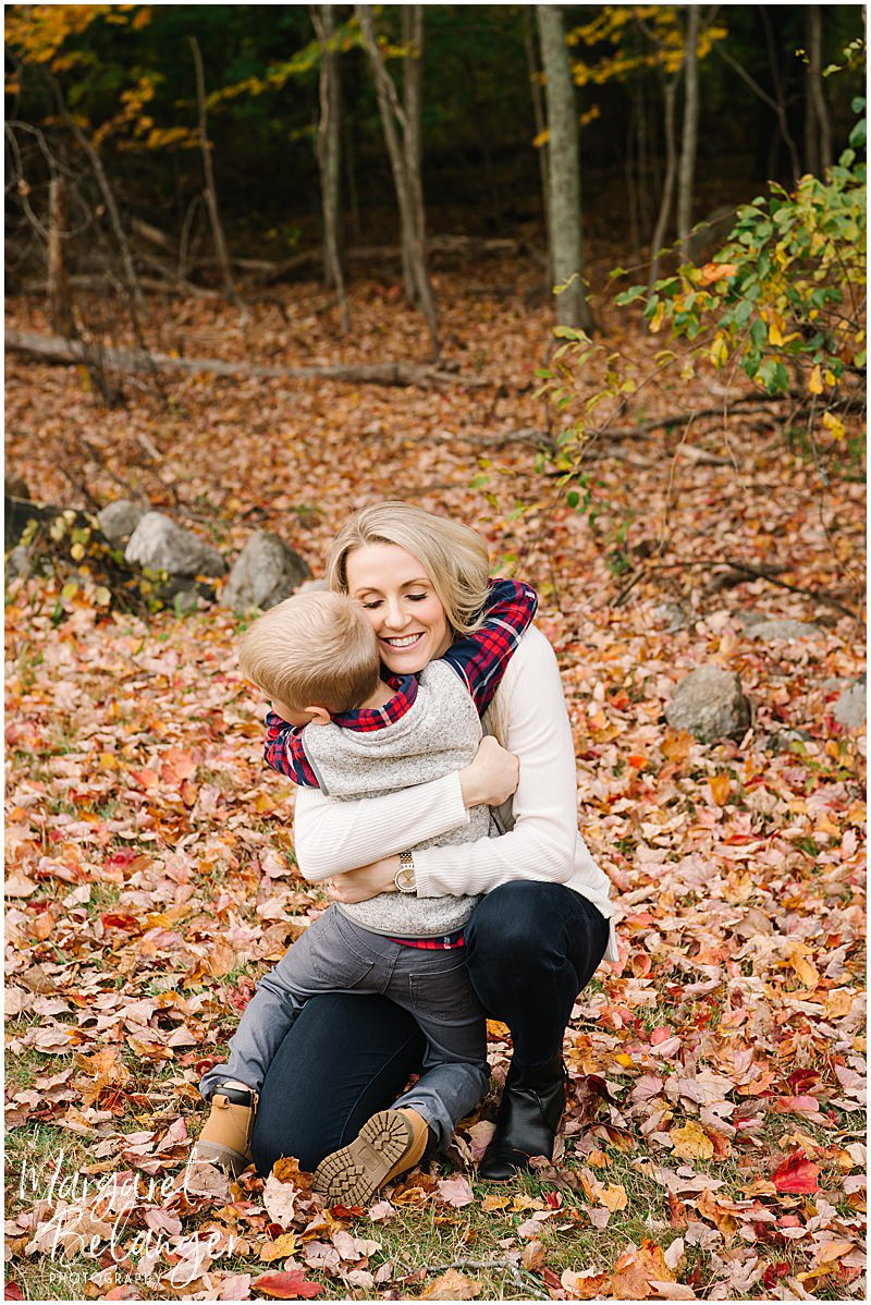Mom hugging her son in the leaves at their Minute Man National Park fall family session