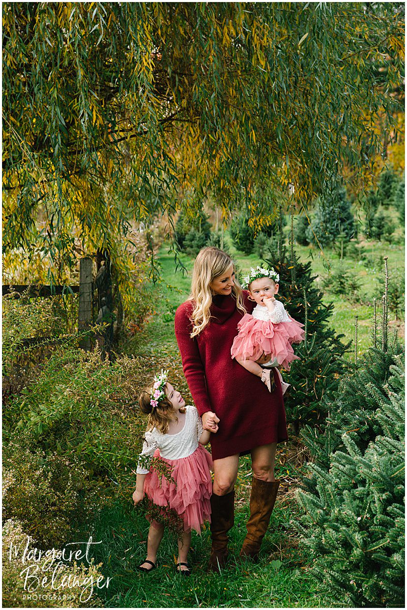 Mom with her two daughters, both wearing tutus, during their fall family session at Mistletoe Christmas Tree Farm in Stow.