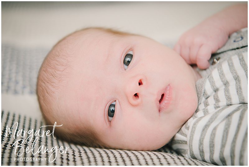Newborn baby boy making a cute face at his Winchester, MA newborn photo session