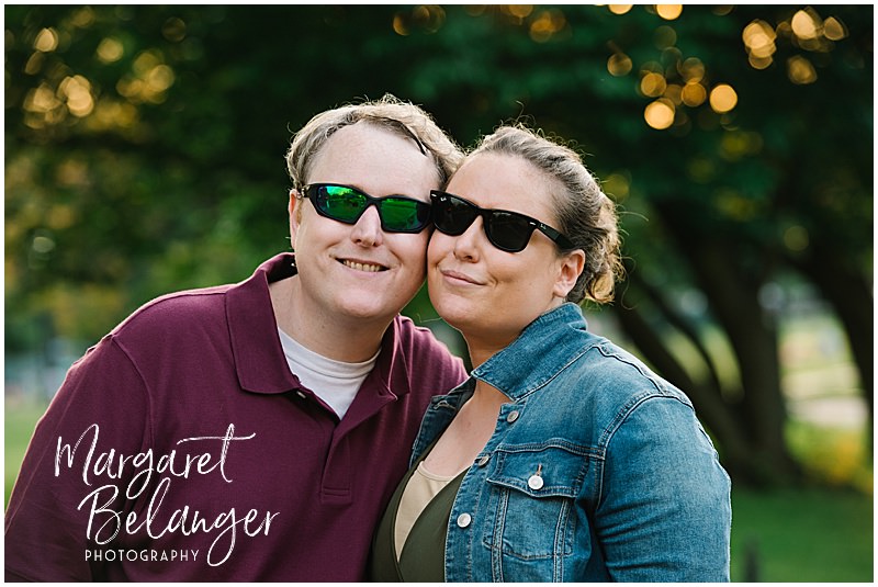 A couple in sunglasses poses cheek-to-cheek for the camera during their Boston Common engagement session.