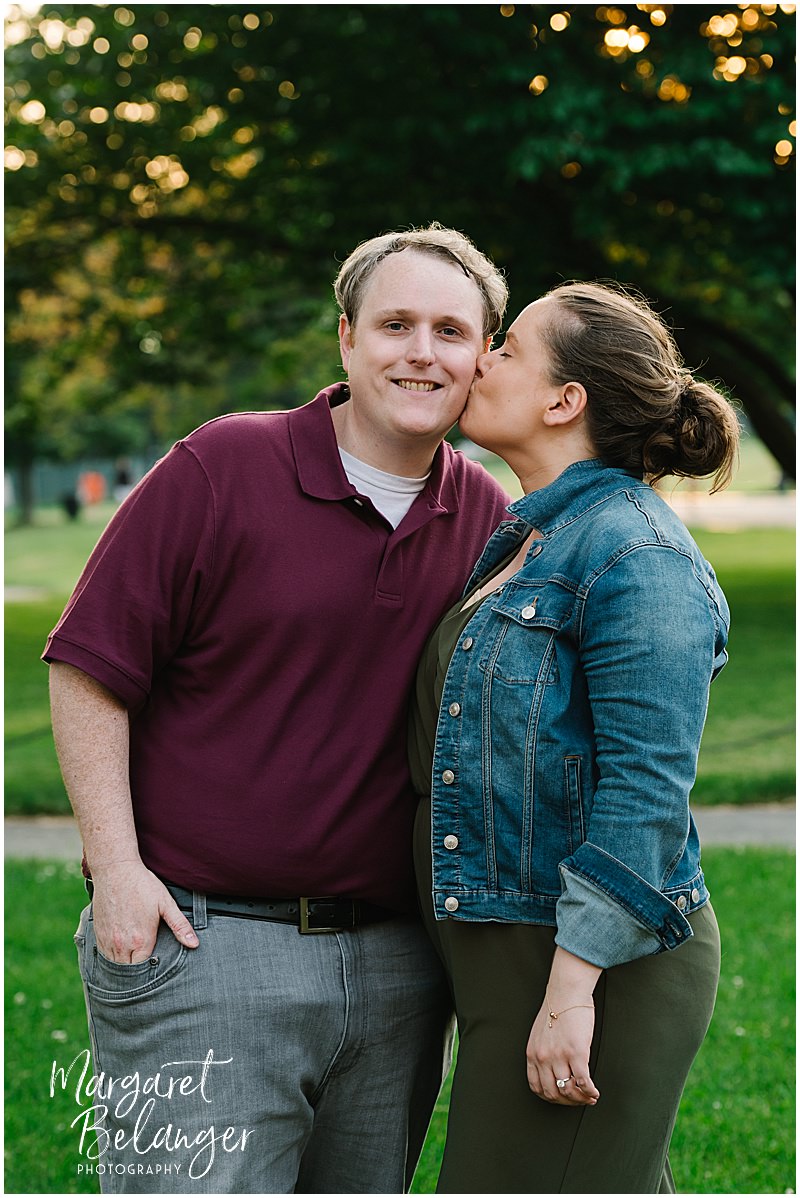 A woman kisses her fiance's cheek during their Boston Common engagement session.