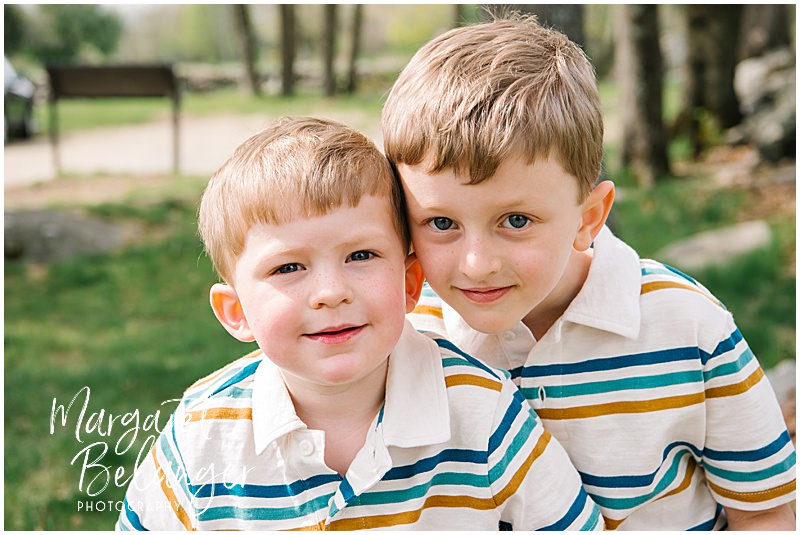 Two brothers smile at the camera during their Minute Man National Park family photo session in Concord.