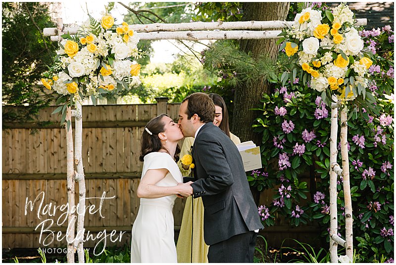 Bride and groom kiss at the end of their wedding ceremony in the backyard of a private residence in Winchester, MA.