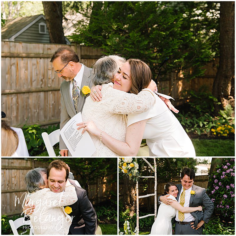 Bride and groom hug their families after their backyard wedding ceremony in Winchester, MA.