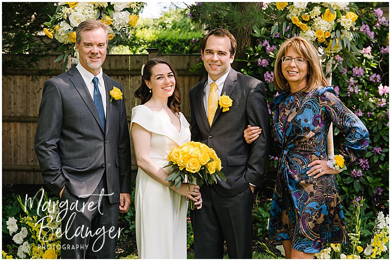 Family portrait of bride and groom with groom's family during their Winchester, MA backyard wedding.