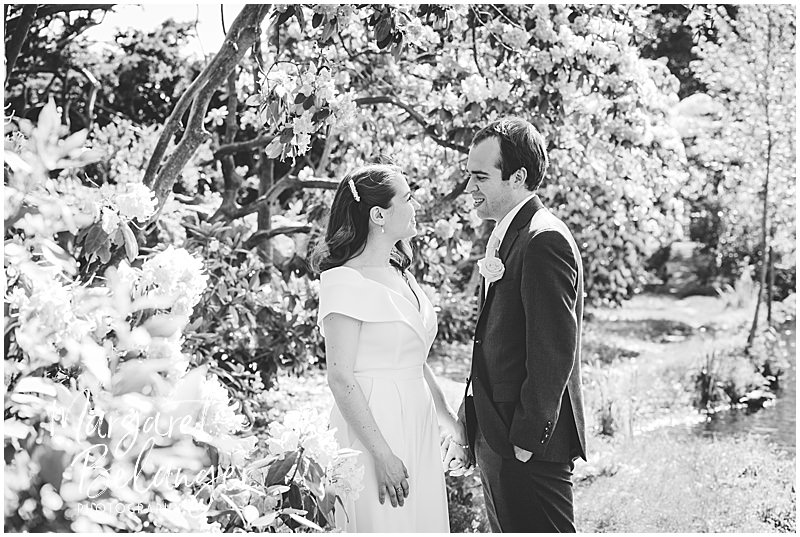 Black and white Bride and groom portraits among the flowers in Winchester Center.