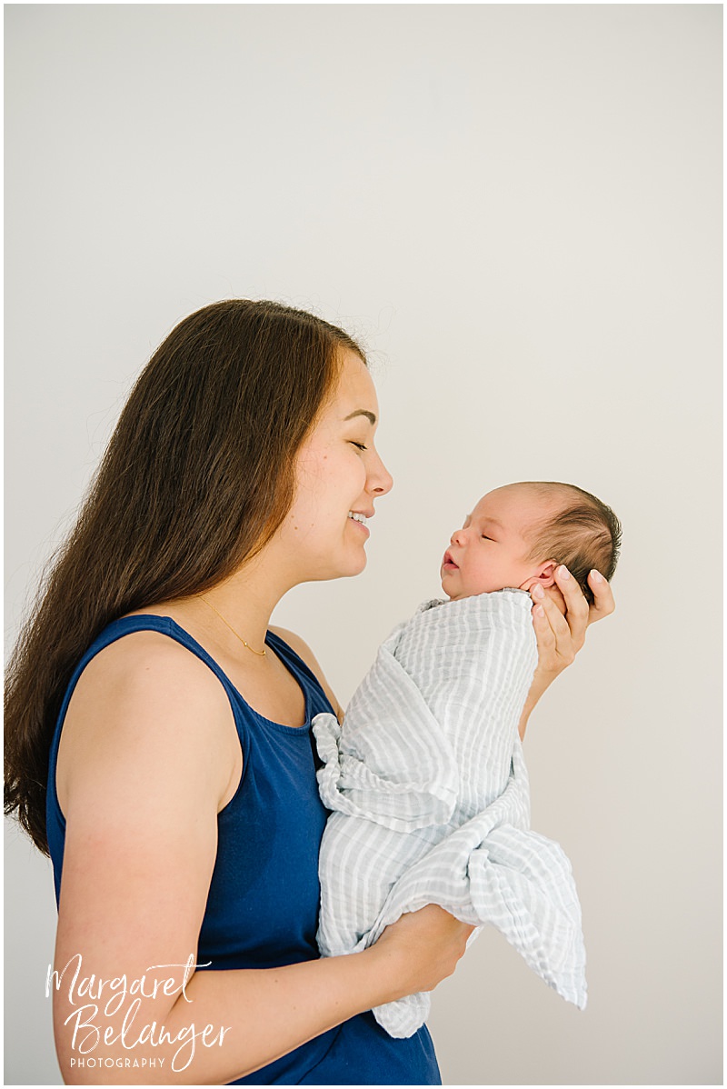 Mom holds her newborn baby boy during an at-home newborn session in Winchester, MA.