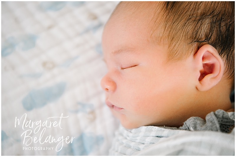 Close-up profile photo of a newborn baby boy sleeping.