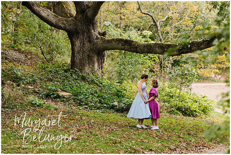 Brides holds hands near a giant tree at Allandale Farm in Brookline