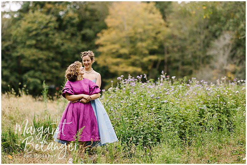 Brides snuggle in a field of purple flowers at Allandale Farm