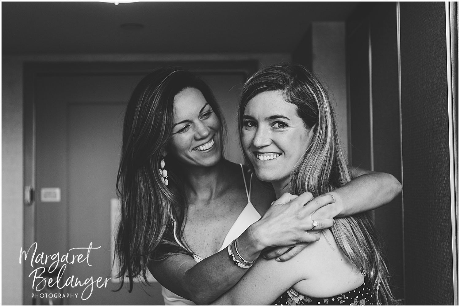 The bride and her sister embracing and smiling in a happy moment.
