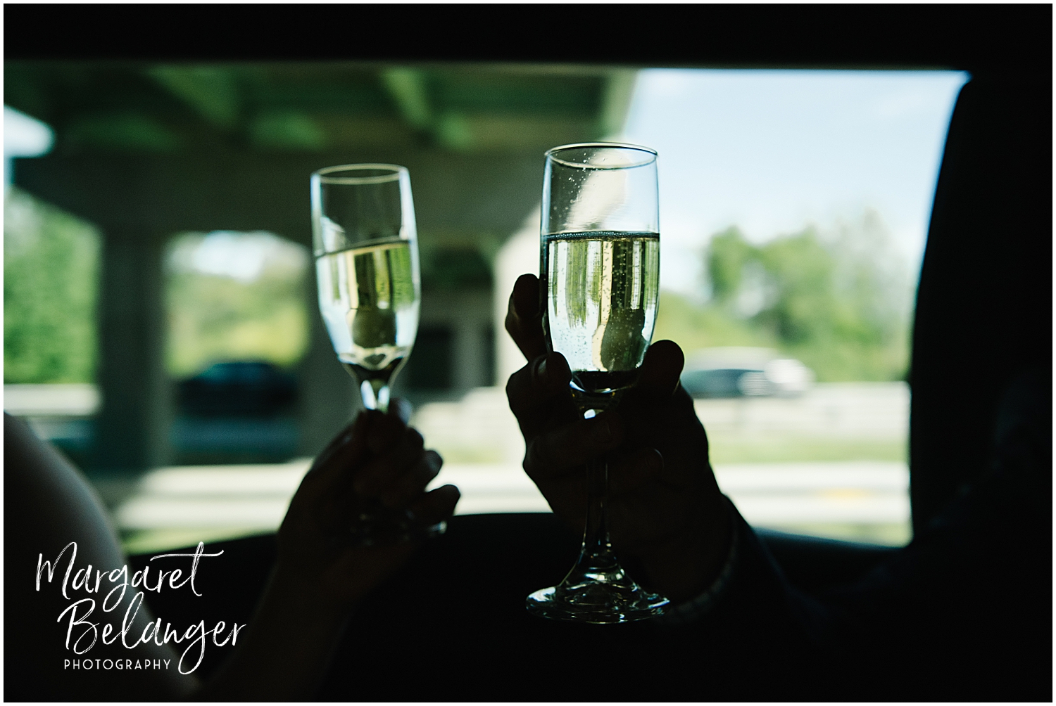 Two people toasting with champagne flutes inside a limousine.